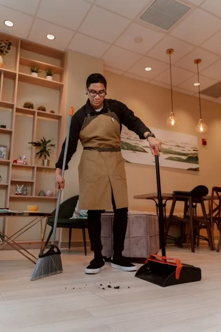 Asian couple having fun while cleaning their home, enhancing a cheerful atmosphere.